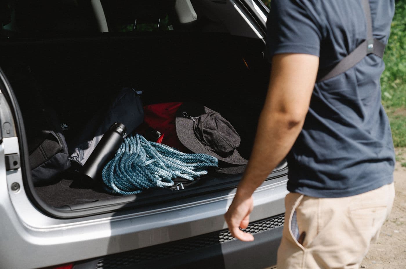 Camping gear being organized in the open trunk of a car