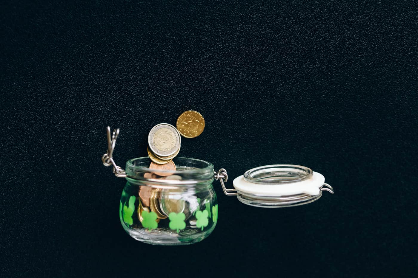 Coins collected in a glass jar on a table