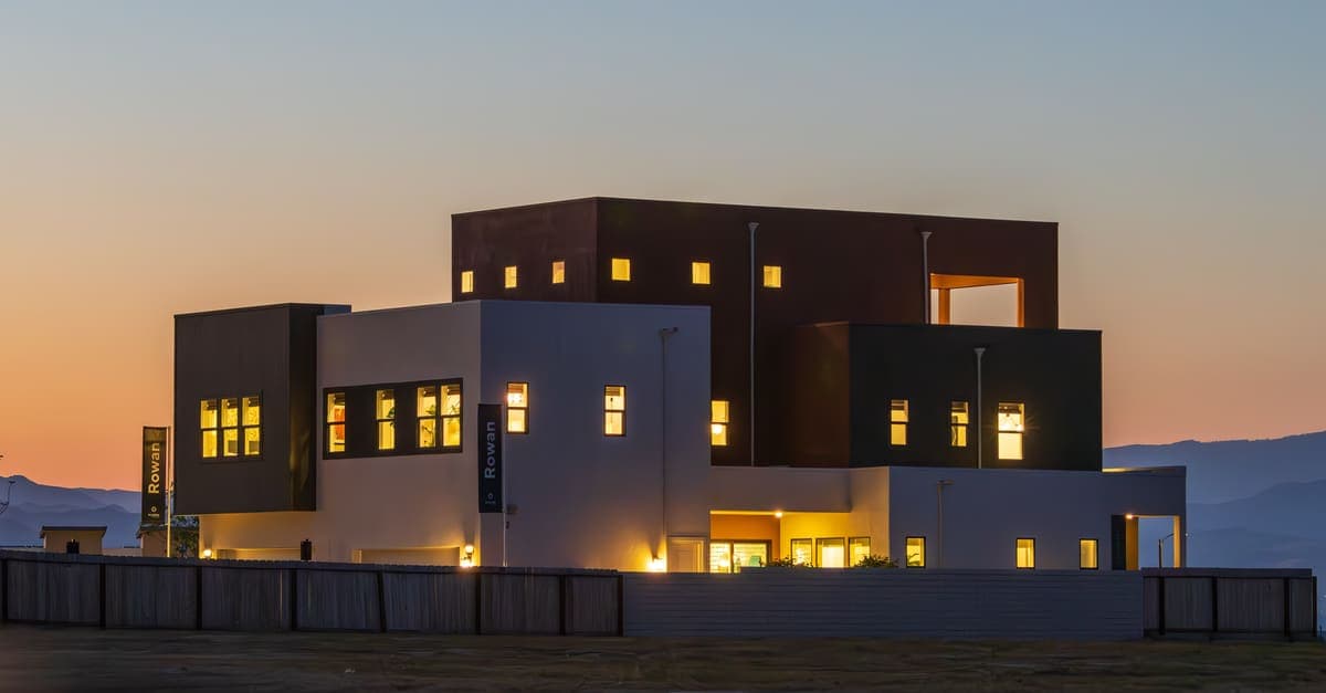 A contemporary house glowing at twilight with its windows lit