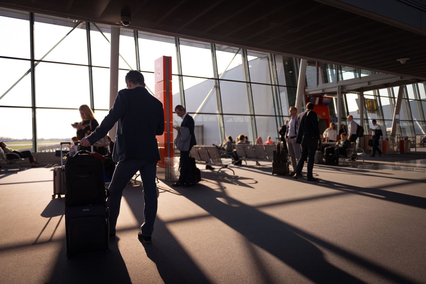 An airport departure terminal with travelers and luggage