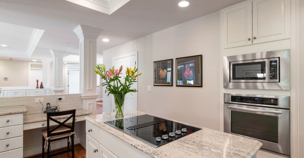 A built-in microwave in a kitchen with granite countertops