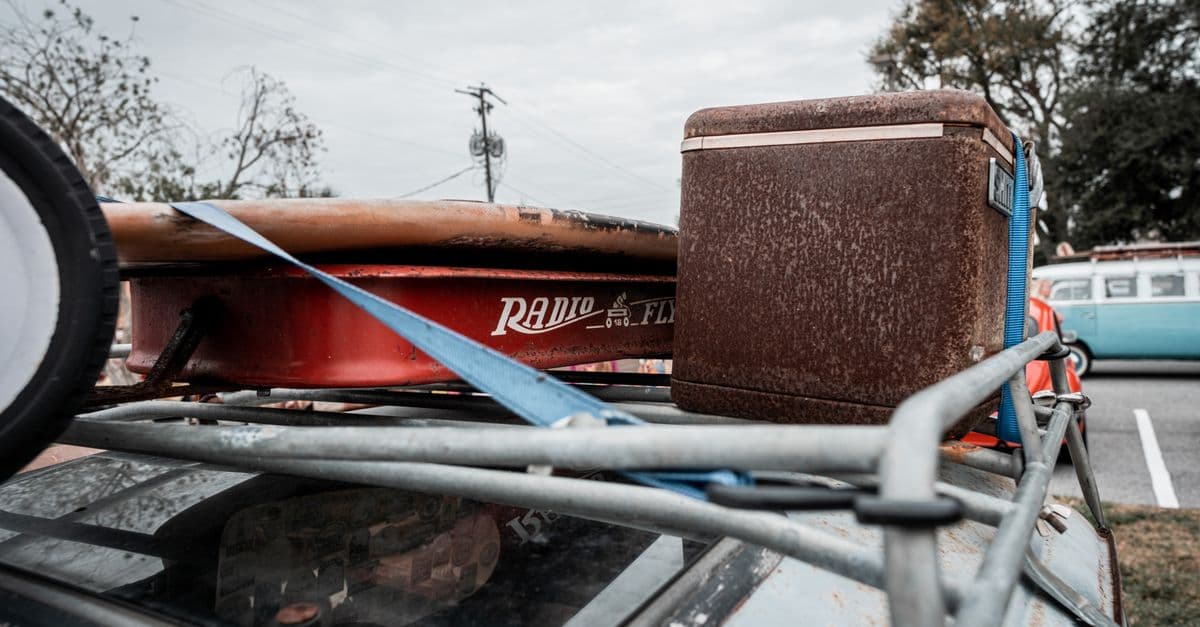 A cooler strapped to the roof of a car on a road trip