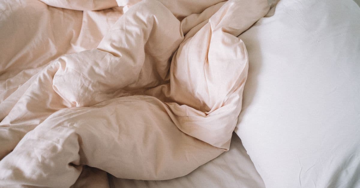 Soft bedding and a pillow arranged on a bed