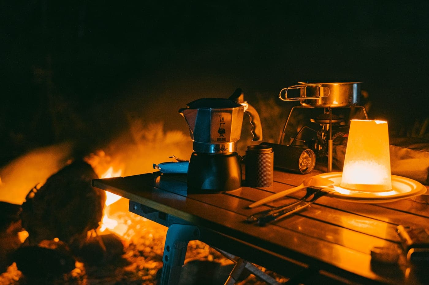 A camping table lit by string lights after dark