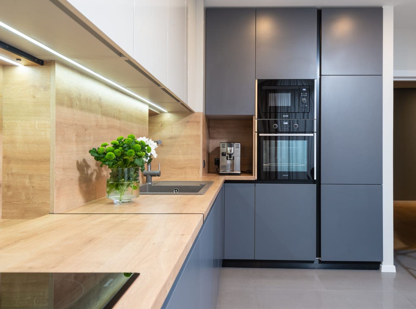 A modern kitchen counter with small appliances plugged in