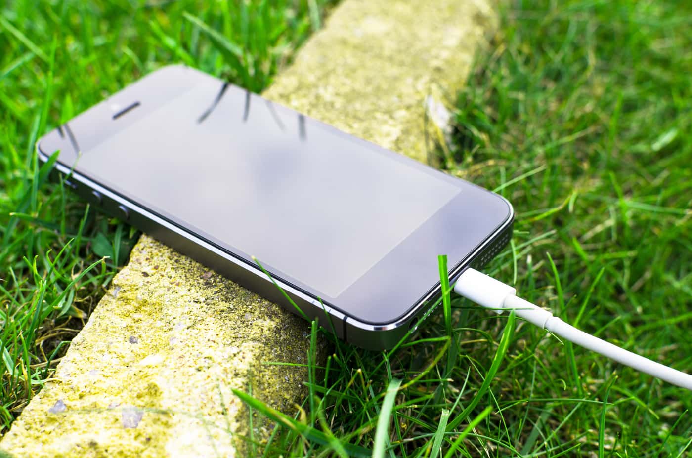 A phone charging from a small battery pack outdoors