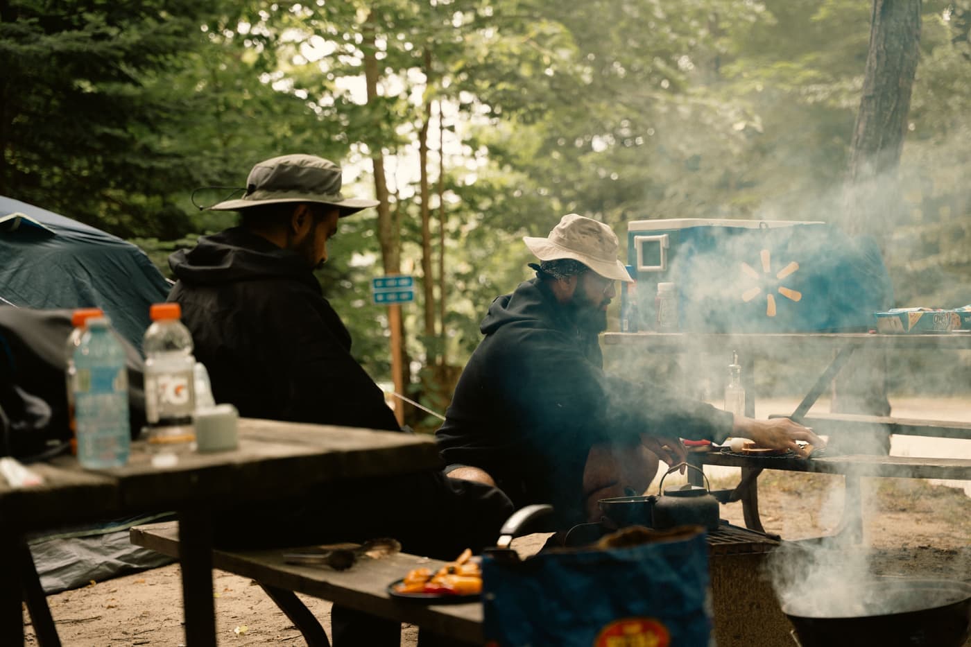 A portable solar panel propped on a picnic table at a campsite