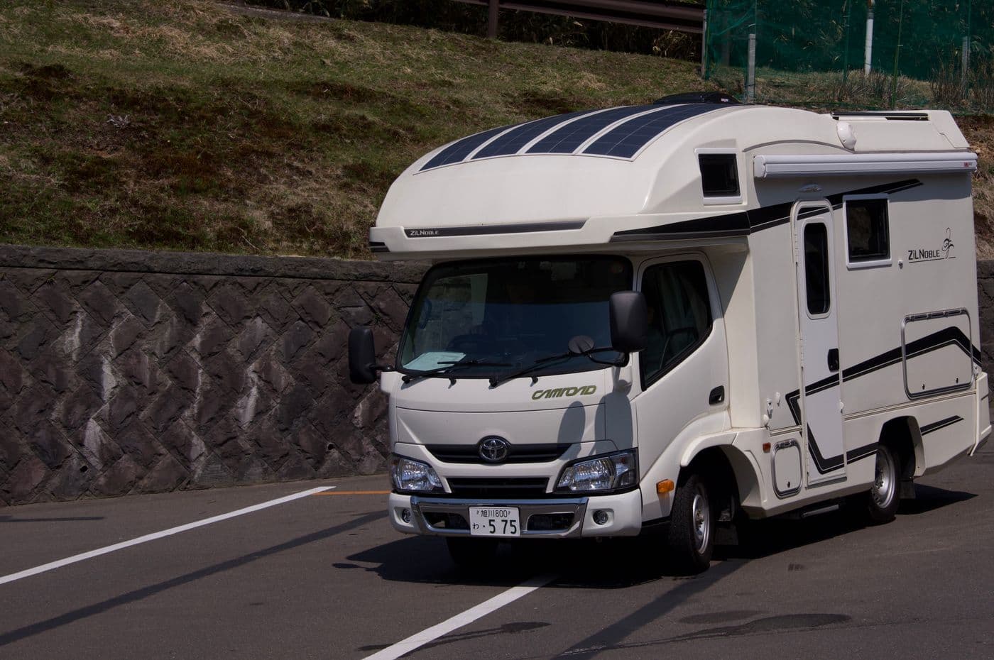 A white camper van parked on a sunny roadside