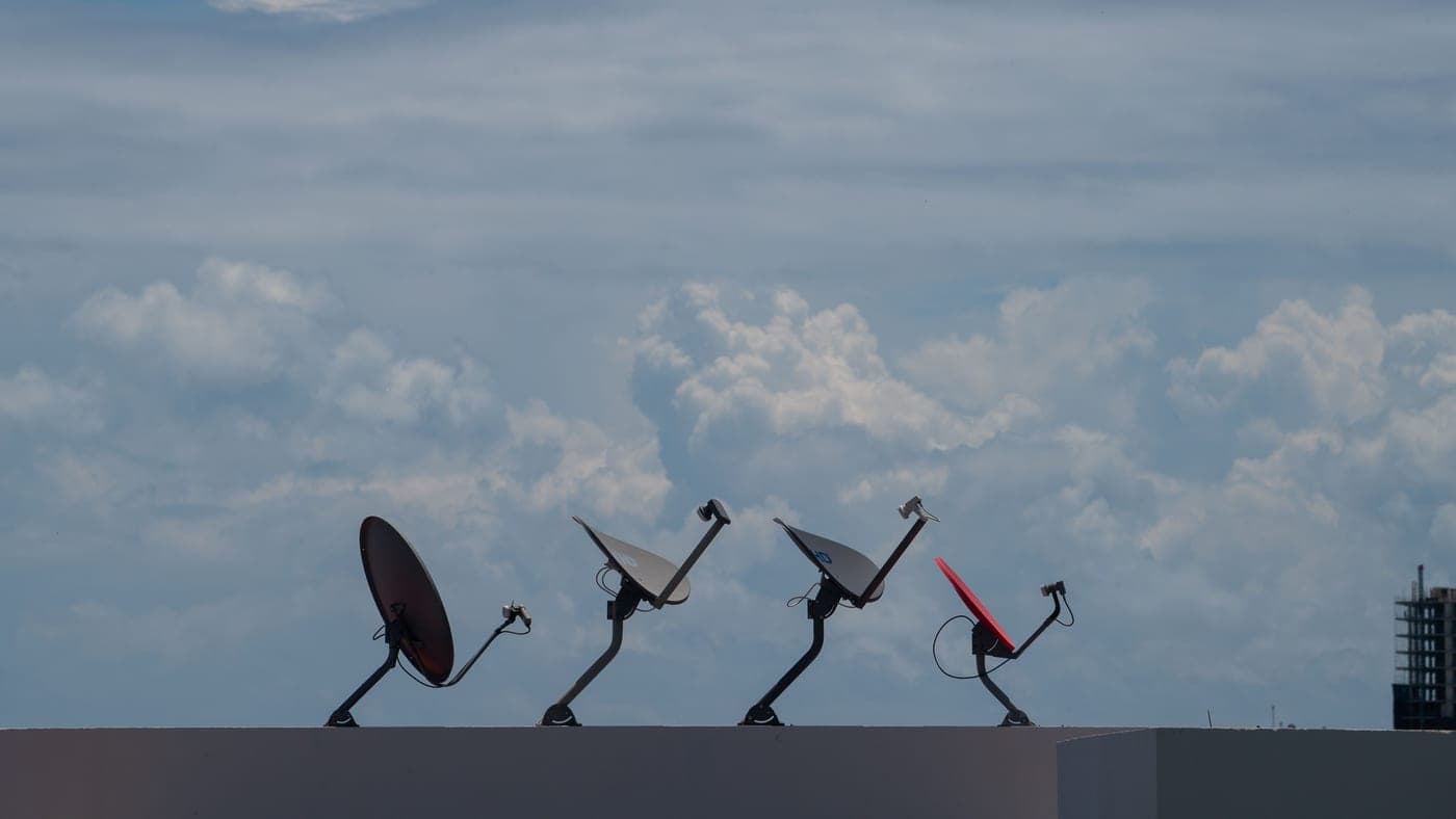A satellite dish mounted outdoors against open sky