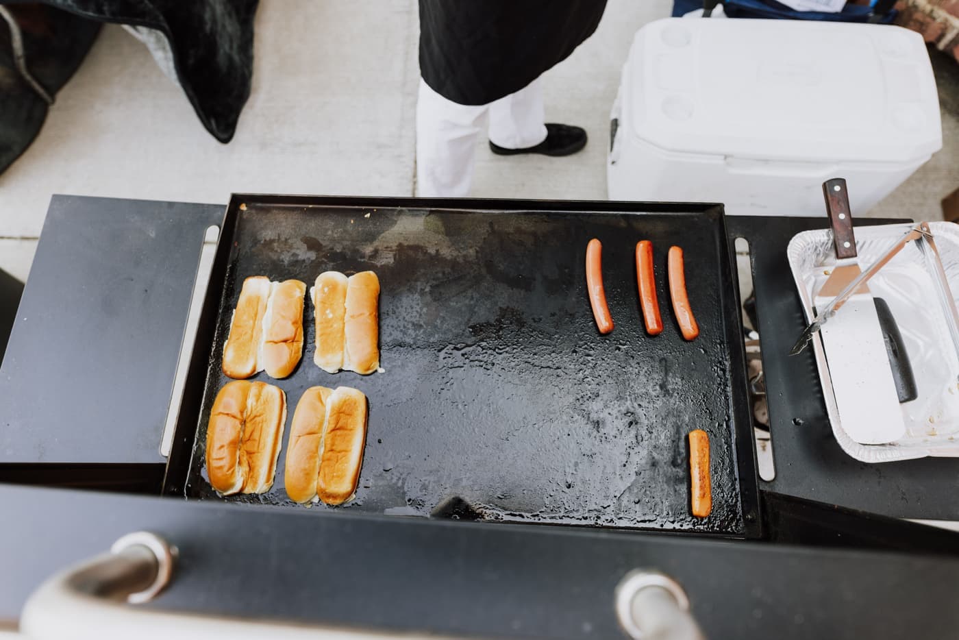 A grill set up beside a vehicle in a parking lot
