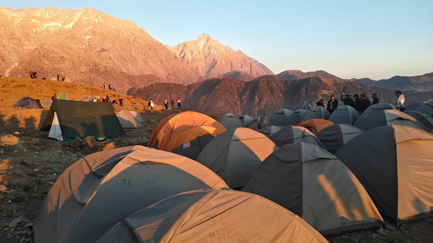 A tent pitched on a mountainside at sunrise