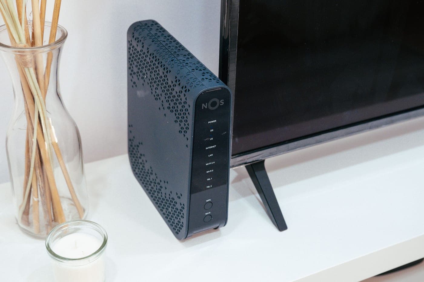 A wifi router and modem on a desk in a home office