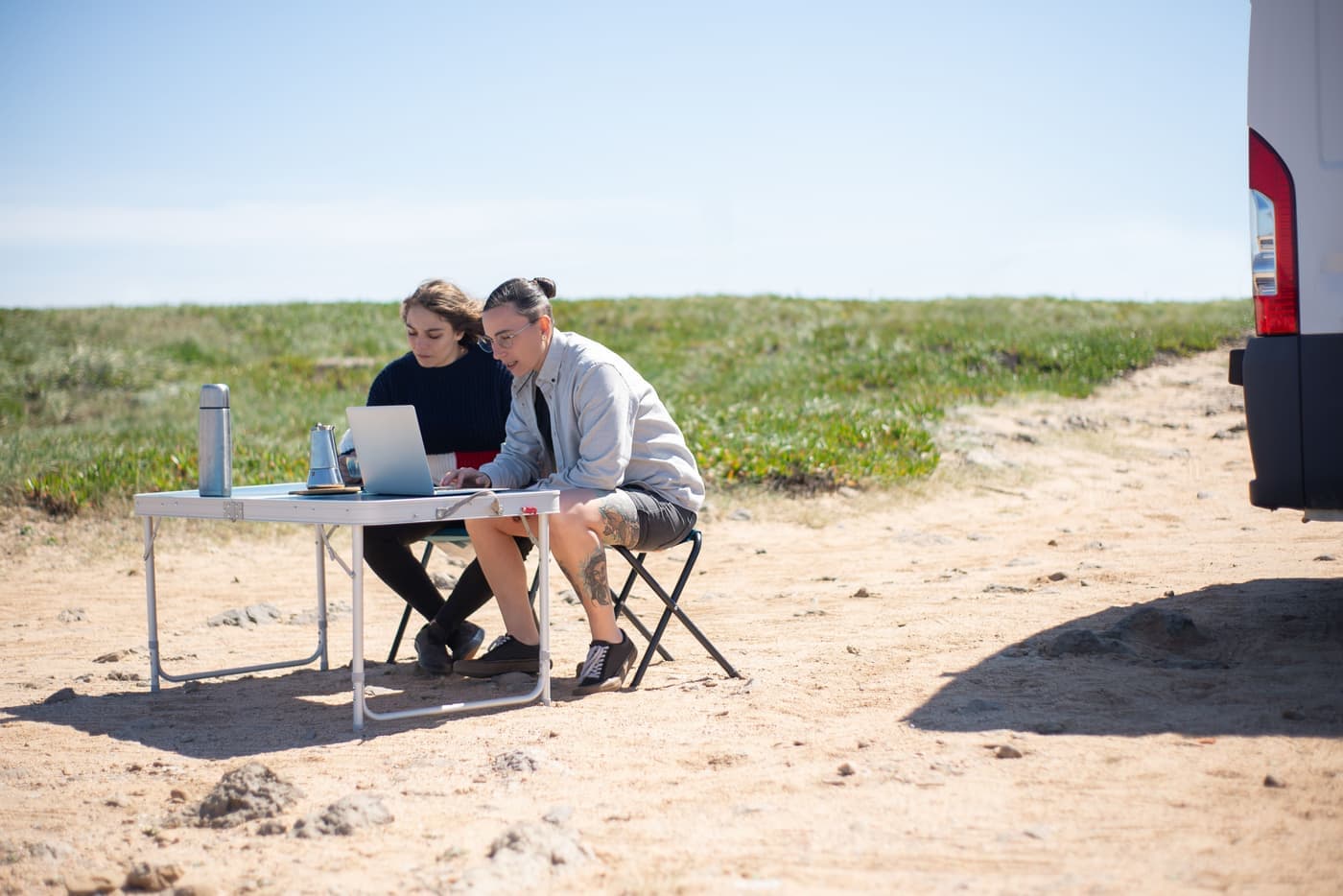 A laptop set up for work inside a camper van parked in the desert