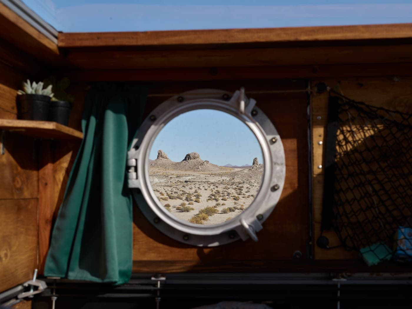 The side door of a camper van open onto a desert landscape