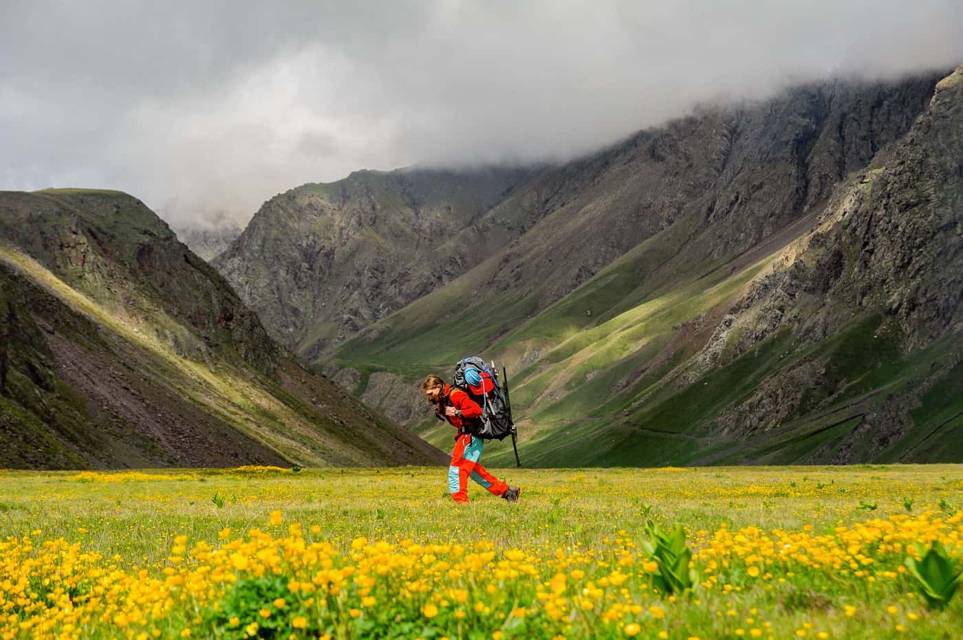 A hiker carrying a heavy loaded backpack on a trail